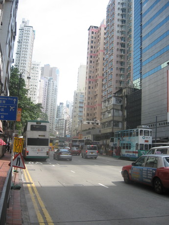 A street with buses, a tram, and taxis