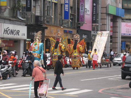 A closer view of the deity figures, waiting to cross the road