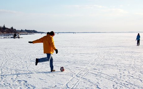 Far og søn spiller snebold på isen